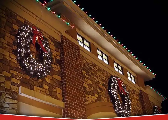 A department store exterior professionally decorated with Christmas lights and wreaths.