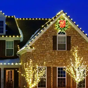A section of residential home exterior decorated with Christmas lights and a light-up LED wreath.